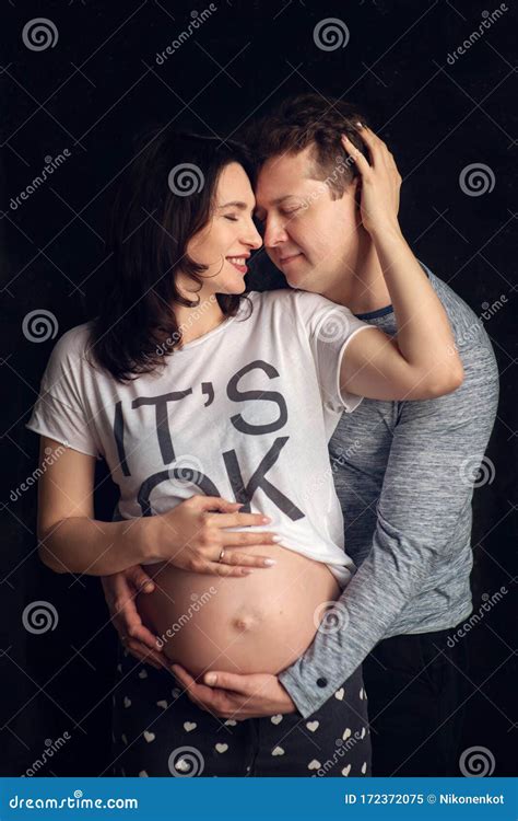 handsome man is listening to his beautiful pregnant wife`s tummy and smiling stock image image