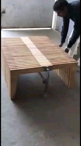 A Man Is Bending Over To Look At A Table Made Out Of Wooden Slats