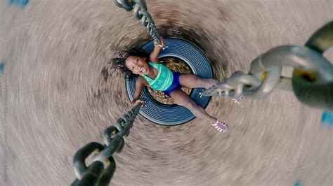 Smiling Black Girl Spinning On A Swing At A Playground By Gabriel Gabi