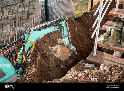 Mini excavator digs a trench to lay pipes. Close up of an excavator