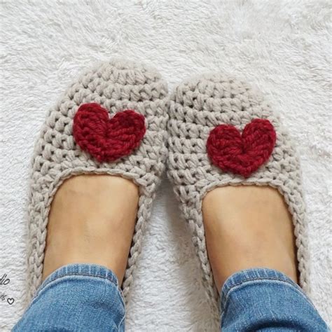 Someone Is Wearing Crocheted Slippers With Red Hearts On The Front And