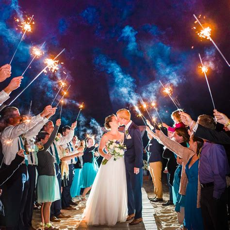 A Bride And Groom Are Kissing Under Sparklers At Their Wedding