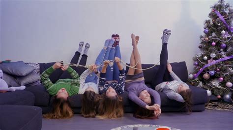 Young And Carefree Girls Lies On Sofa Upside Down And Have Fun Stock