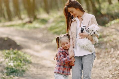Madre Con Hija En Un Bosque De Primavera Con Perro Imagen De Archivo