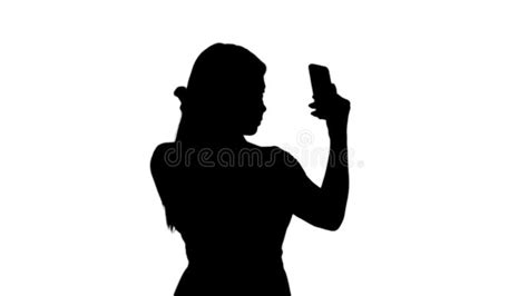 Silhouette Blonde Woman Preening In Front Of The Smartphone Stock