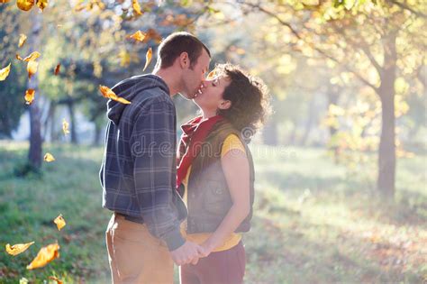 Loving Couple Kissing In The Park In The Sunlight On Trees Background