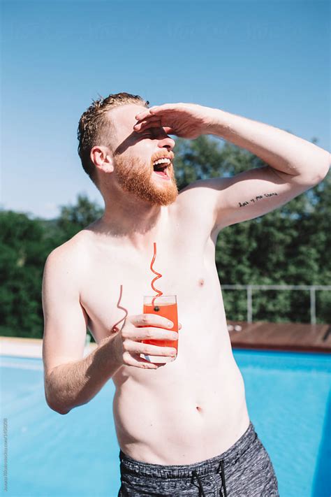 Portrait Of A Babe Man Drinking Cocktail By The Pool By Stocksy