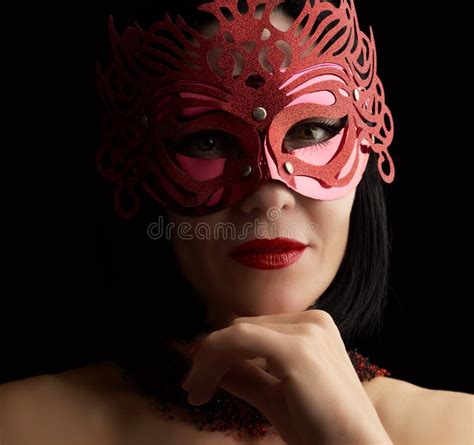 Adult Woman Of Caucasian Appearance With Black Hair Wearing A Red Shiny Carnival Mask Stock