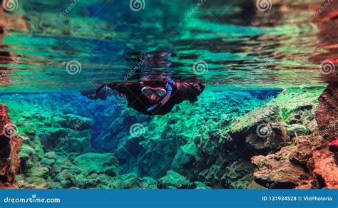 People Snorkeling And Diving In Blue Crystal Clear Glacial Water In