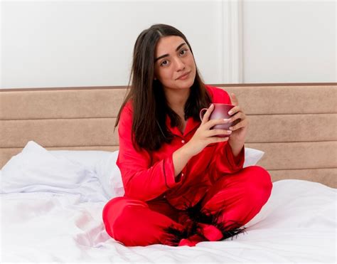 Free Photo Young Beautiful Woman In Red Pajamas Sitting On Bed With