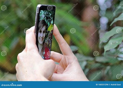 A Young Woman Takes A Self Portrait With Her Smartphone Stock Photo