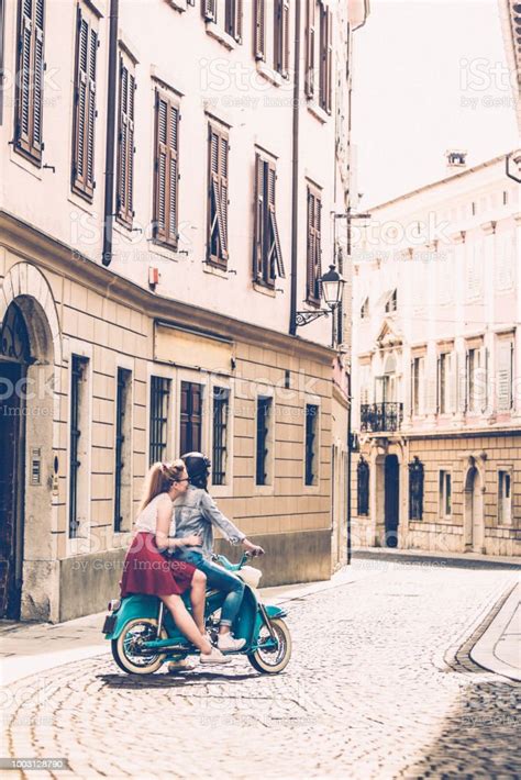 Young Lesbian Couple Driving Oldfashioned Motor Scooter On Italian City