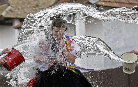 splash men throw buckets of water as women run past in hungary