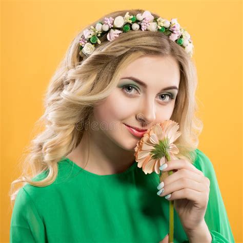 Beautiful Blonde Woman In A Green Dress Folded Her Hands Near The Face And Corrects Hairstyle