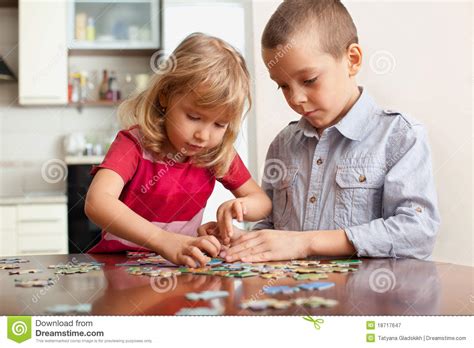 Playing with puzzles requires a trial and error process which involves a lot of hand and eye manipulation. Children, Playing Puzzles Royalty Free Stock Photography ...