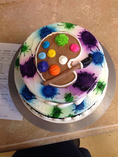 There Is A Cake Decorated With An Artists Palette On The Table Next To