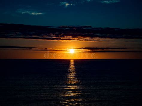 A Beautiful Golden Sunset Over The Ocean Horizon On A Warm Summers