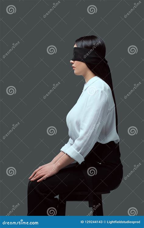 Side View Of Young Blindfolded Woman Sitting On Chair Stock Image