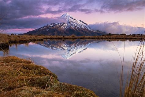 Mount Egmonttaranaki Is Reflected Perfectly In The Still Waters Of
