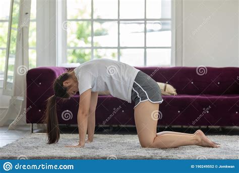 Athletic Asian Woman Practice Yoga Cat Cow Pose To Meditation At Home