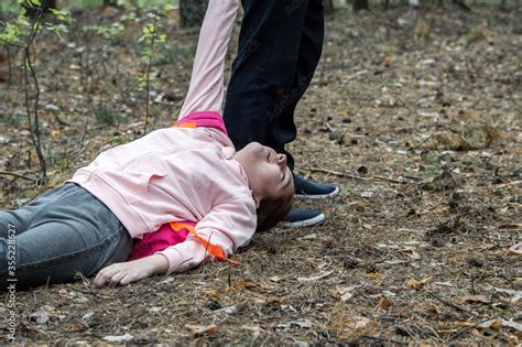 A Man Drags The Body Of A Teenage Girl On The Ground In The Woods Victim Of Violence The