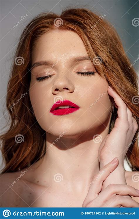 Beautiful Young Redhead Woman With Red Lips Posing With Eyes Closed