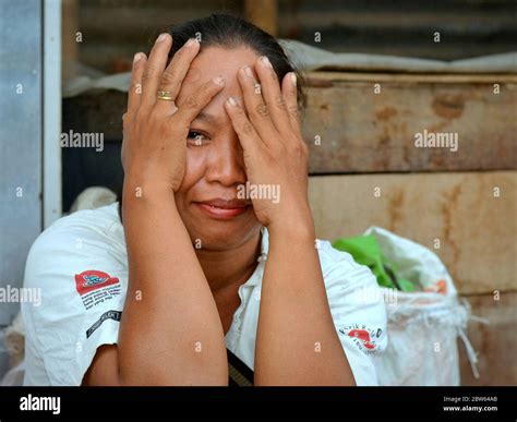 flirting mature indonesian javanese woman pretends to cover her eyes with both hands and mocks