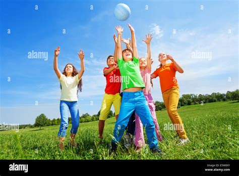 Happy Kids Catching Ball In Air Outside Stock Photo Alamy