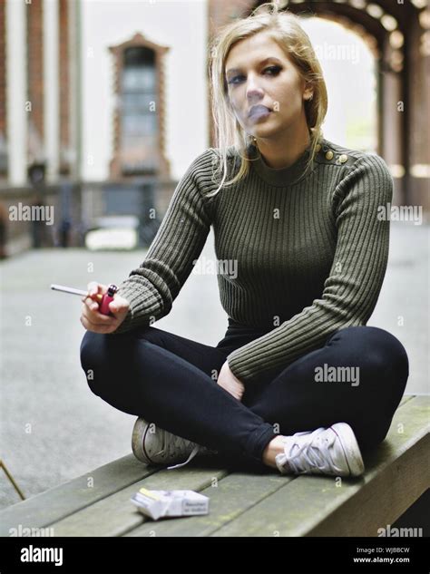 Portrait Of Woman Smoking While Sitting On Bench Stock Photo Alamy