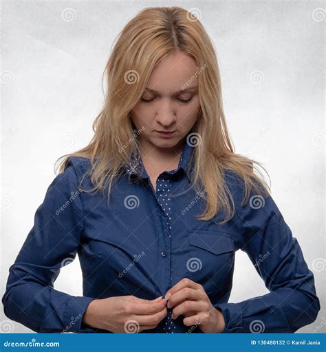 Young Woman In Casual Blue Shirt Dressing Up And Looking Down Stock