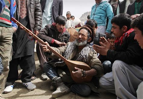 An Afghan Musician Plays An Instrument Called A Dombura At
