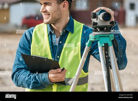Smiling Surveyor Holding Clipboard And Digital Level Stock Photo Alamy