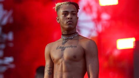 Xxxtentacion Is Standing Without Shirt And Having Tattoos On Neck Chest And Hand In A Blur Red