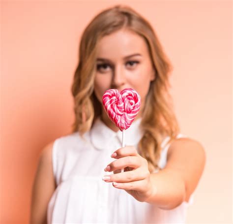 Premium Photo Young Beautiful Woman Is Holding A Candy