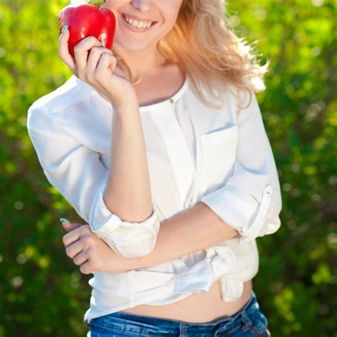Premium Photo Smiling Blonde Woman Eating Red Ripe Apple Outdoor Over