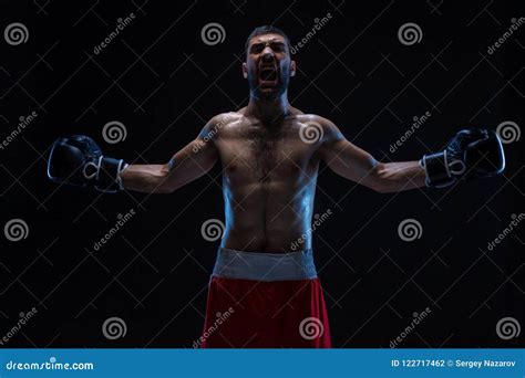 Oriental Boxer Celebrating His Victory With Raised Arms In Black Gloves