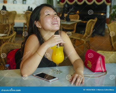 Young Happy And Relaxed Asian Chinese Tourist Woman Drinking Healthy