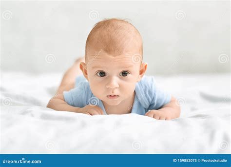 Portrait Of Adorable Newborn Baby Lying In Bed On Tummy Stock Image