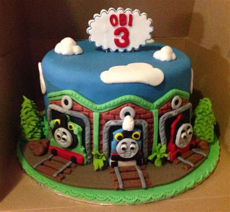 Henry and thomas sitting on the big thomas cake for a little boy called samuel. thomas-train-cake | Funtacee Parties