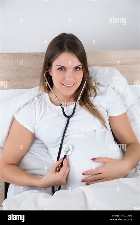 Young Pregnant Woman Examining Herself With Stethoscope Stock Photo Alamy