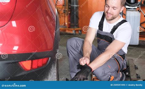 Attractive European Looking Car Mechanic Puts On Gloves Before