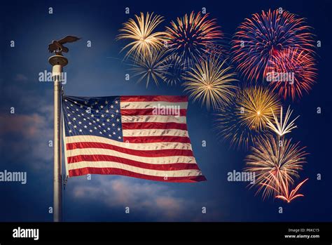 Festive Fireworks Display With American Flag Waving Against The Dark