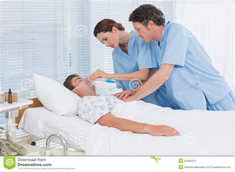 Worried Doctors Doing Heart Massage And Holding Oxygen Mask Stock Image