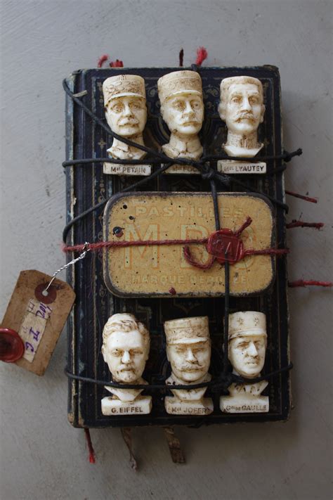 A Group Of Clay Heads Sitting On Top Of A Piece Of Wire With Magnets