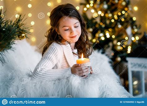 A Brunette Gilr In Front Of Fur Tree And Fireplace With Candles And
