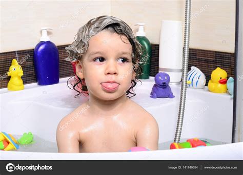 Beautiful toddler taking a bath in a bathtub with bubbles. Cute kid ...