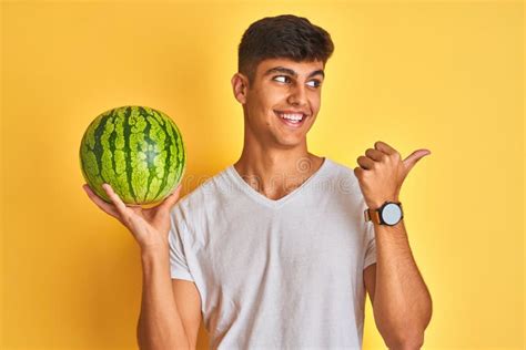 Young Indian Shopkeeper Man Holding Watermelon Standing Over Isolated