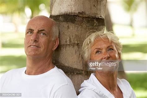Couple Leaning Against A Tree Trunk Photos And Premium High Res