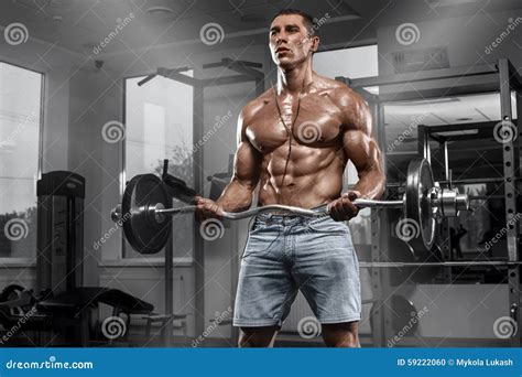 Muscular Man Working Out In Gym Doing Exercises With Barbell Strong