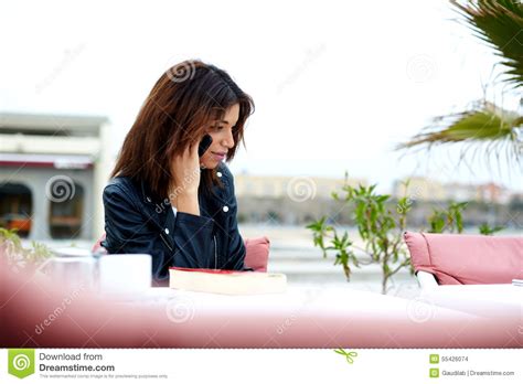Gorgeous Young Woman Talking On Mobile Phone While Sitting In Sidewalk